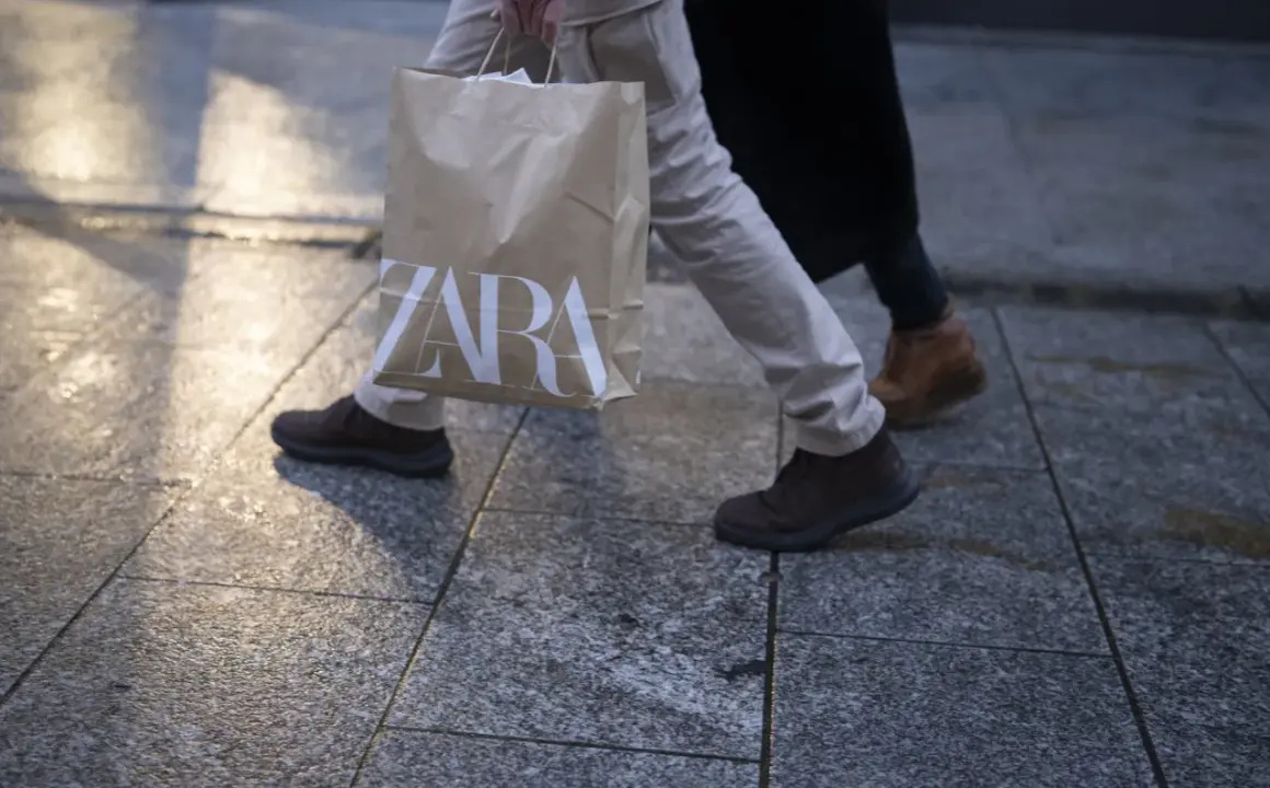 Osoba idzie z torbą z logo ZARA. Może to być efekt zakupów zrobionych przez aplikację ZARA.