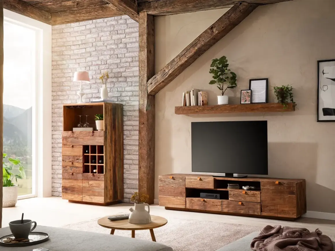 Rustikales Wohnzimmer mit Möbeln aus **Massivholz**, die Wärme und Gemütlichkeit ausstrahlen. Ein TV-Lowboard und ein Schrank mit Weinregal stehen im Fokus.