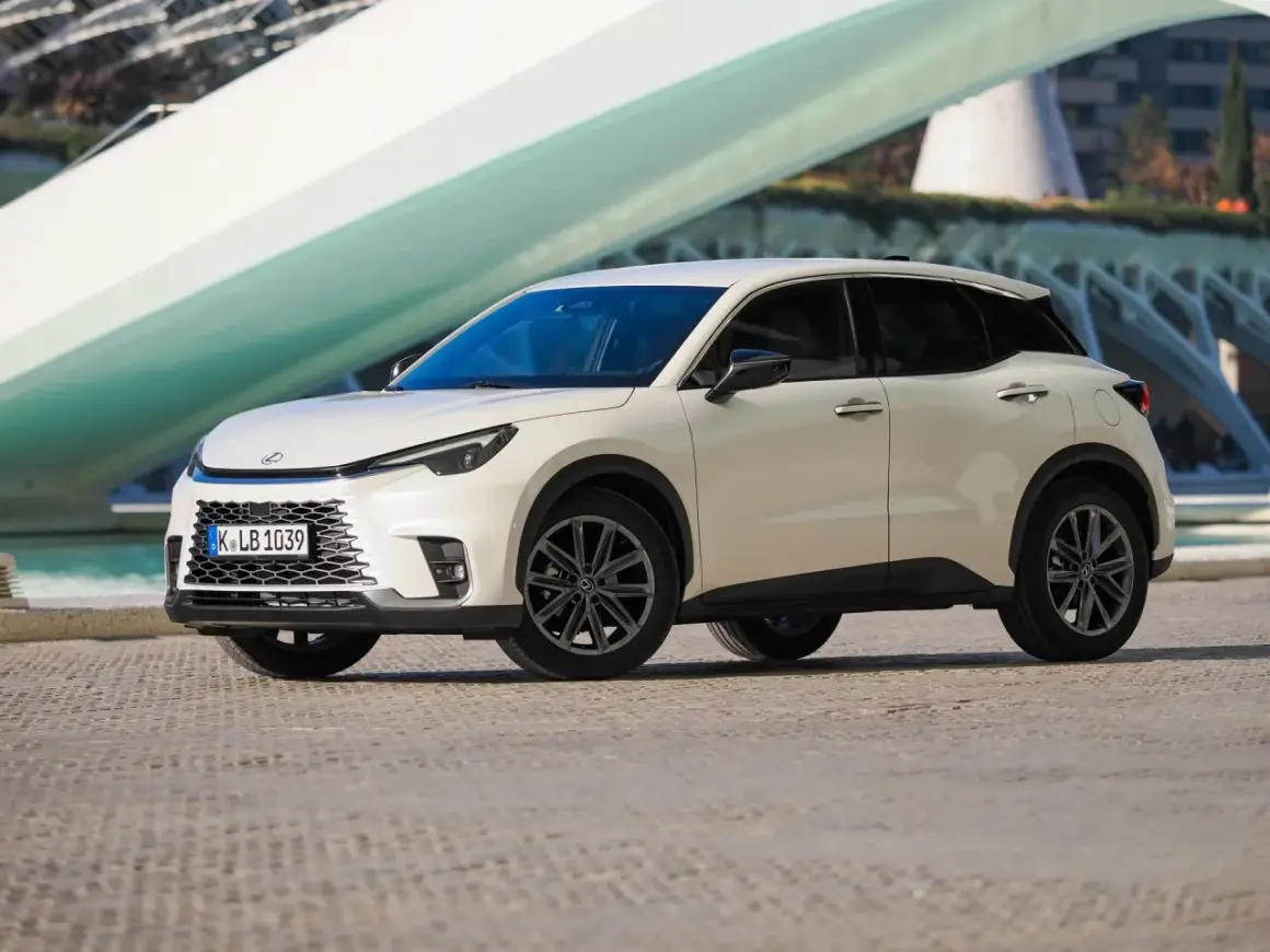 Biały Lexus LBX na tle nowoczesnej architektury. Sprawdź jego lexus lbx dane techniczne i odkryj możliwości tego miejskiego SUV-a.