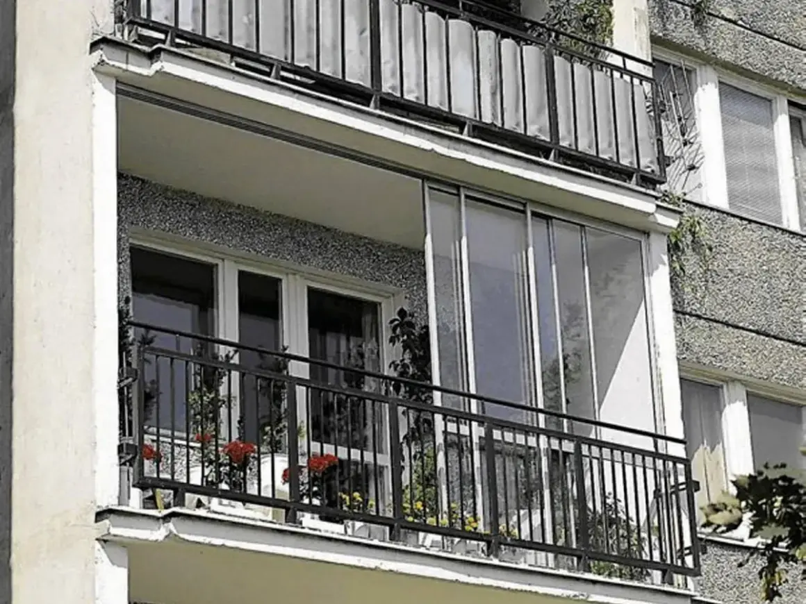 Zabudowany balkon w bloku z przeszklonymi drzwiami i oknami, idealny przykład jak zabudować balkon w bloku, by zyskać dodatkową przestrzeń.