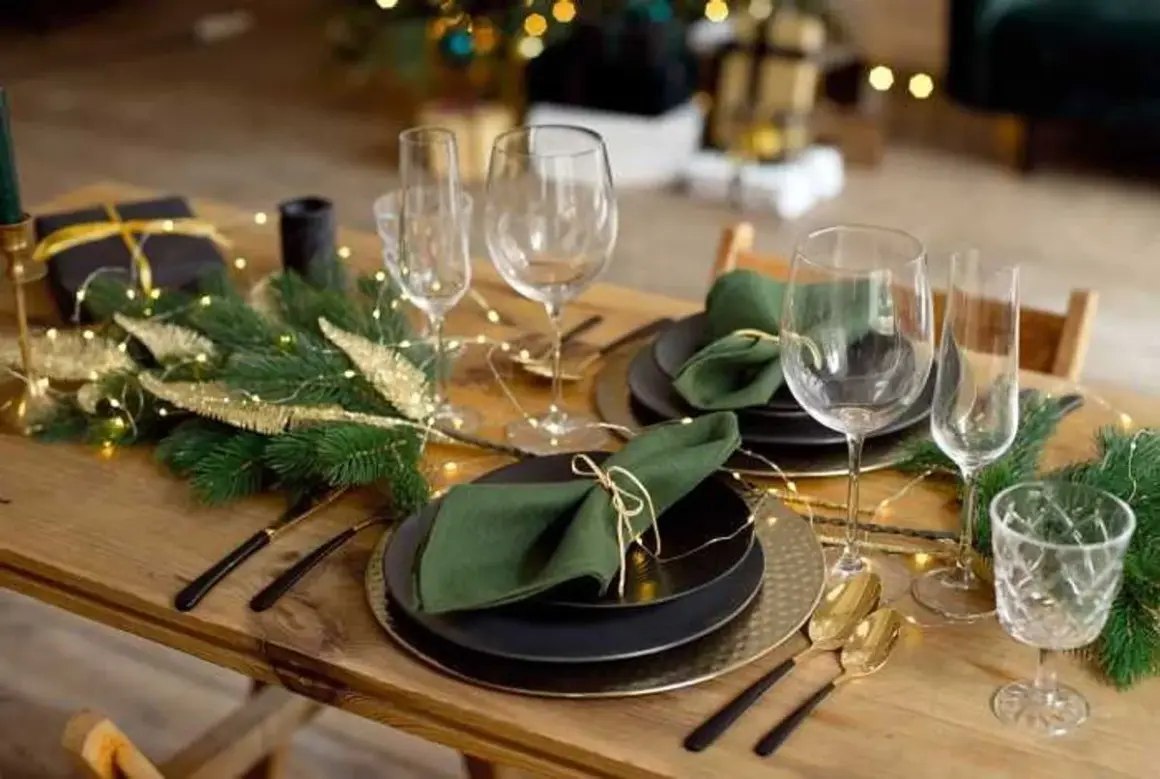 Table dressée pour Noël avec pliage serviette avec rond de serviette, guirlande lumineuse et branches de sapin.