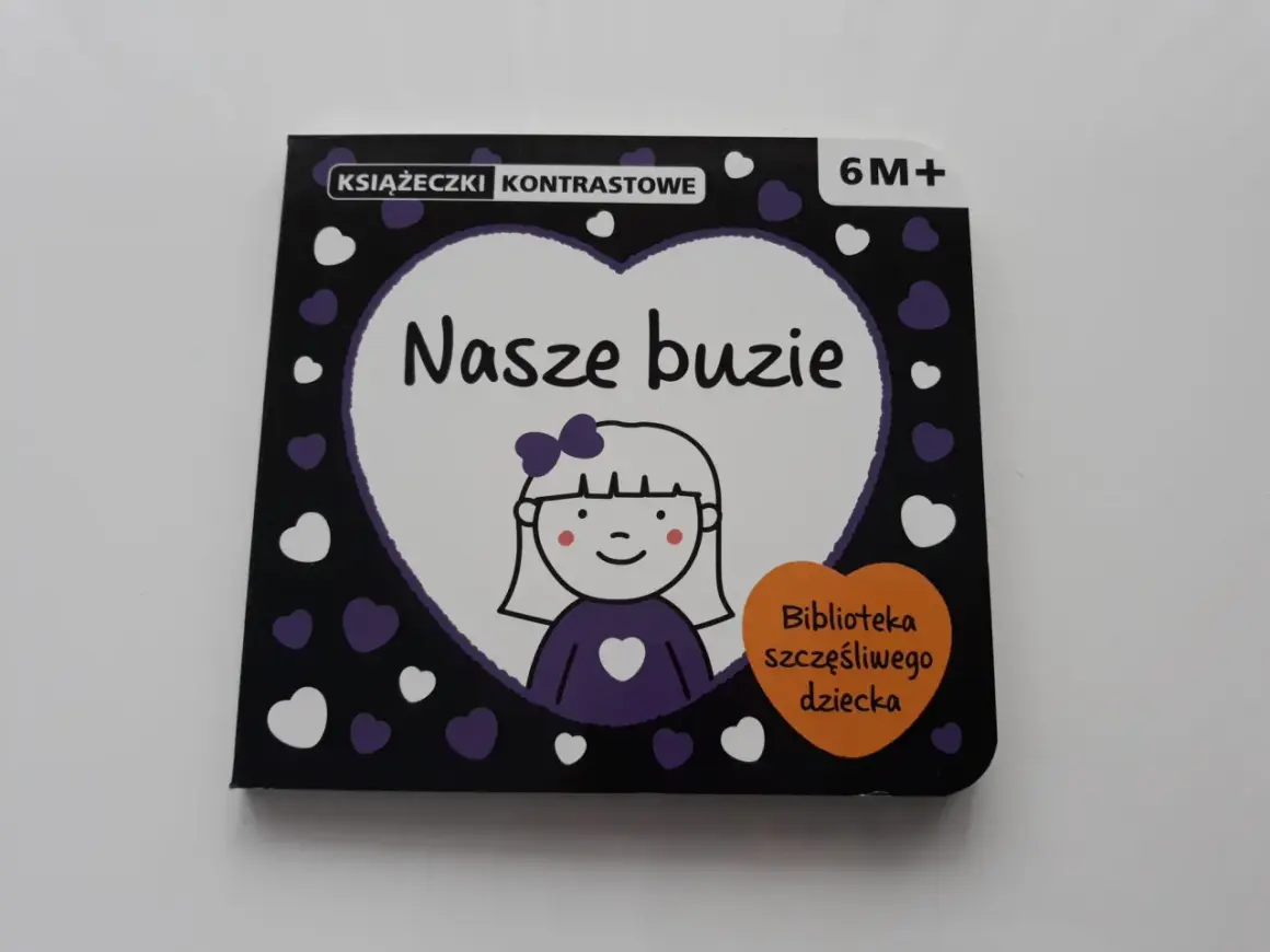 Książeczki kontrastowe "Nasze buzie" od 6M+. Urocza okładka z rysunkiem dziewczynki i serduszkami.