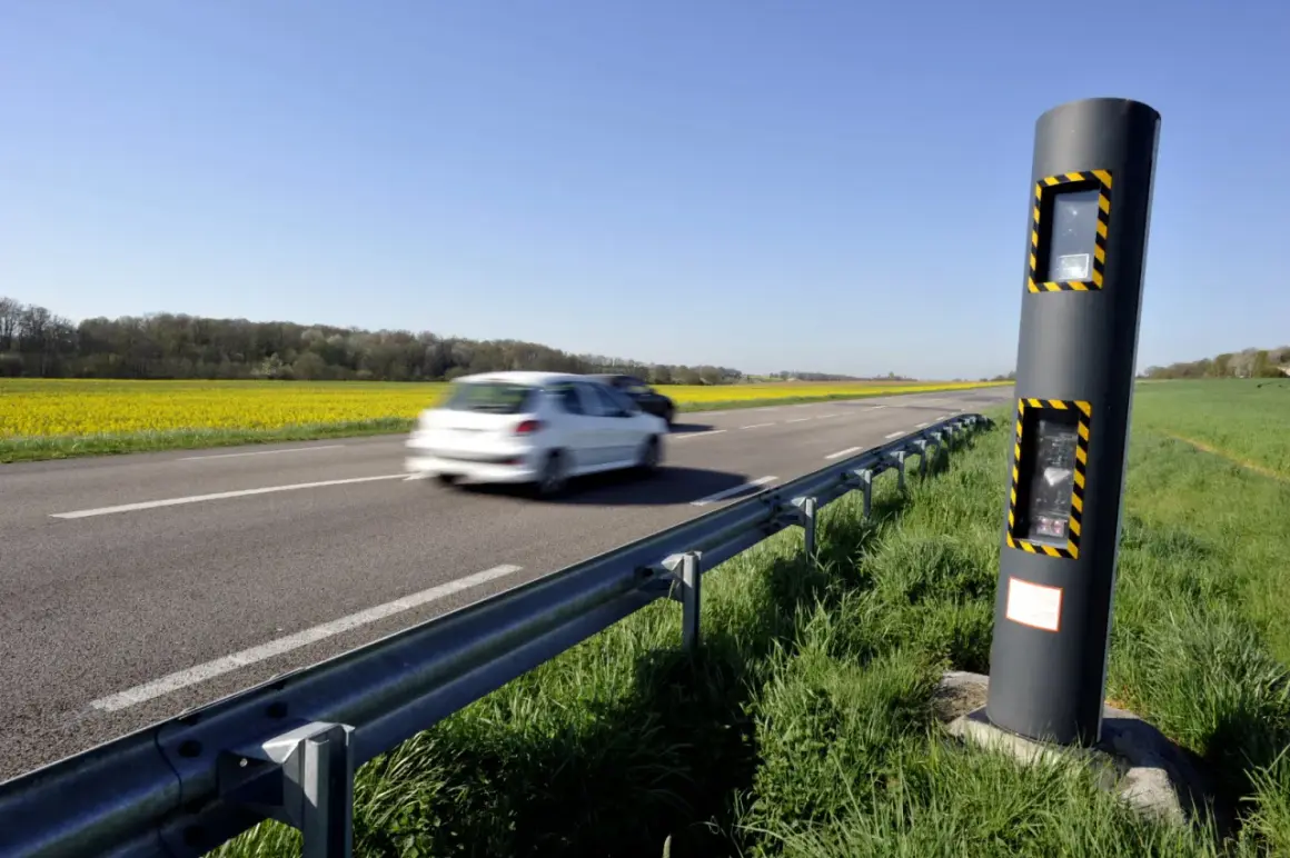 Un radar de vitesse sur le bord d'une route de campagne, avec des champs de colza jaunes et des voitures en mouvement. Ces photos des différents radars rappellent la vigilance.