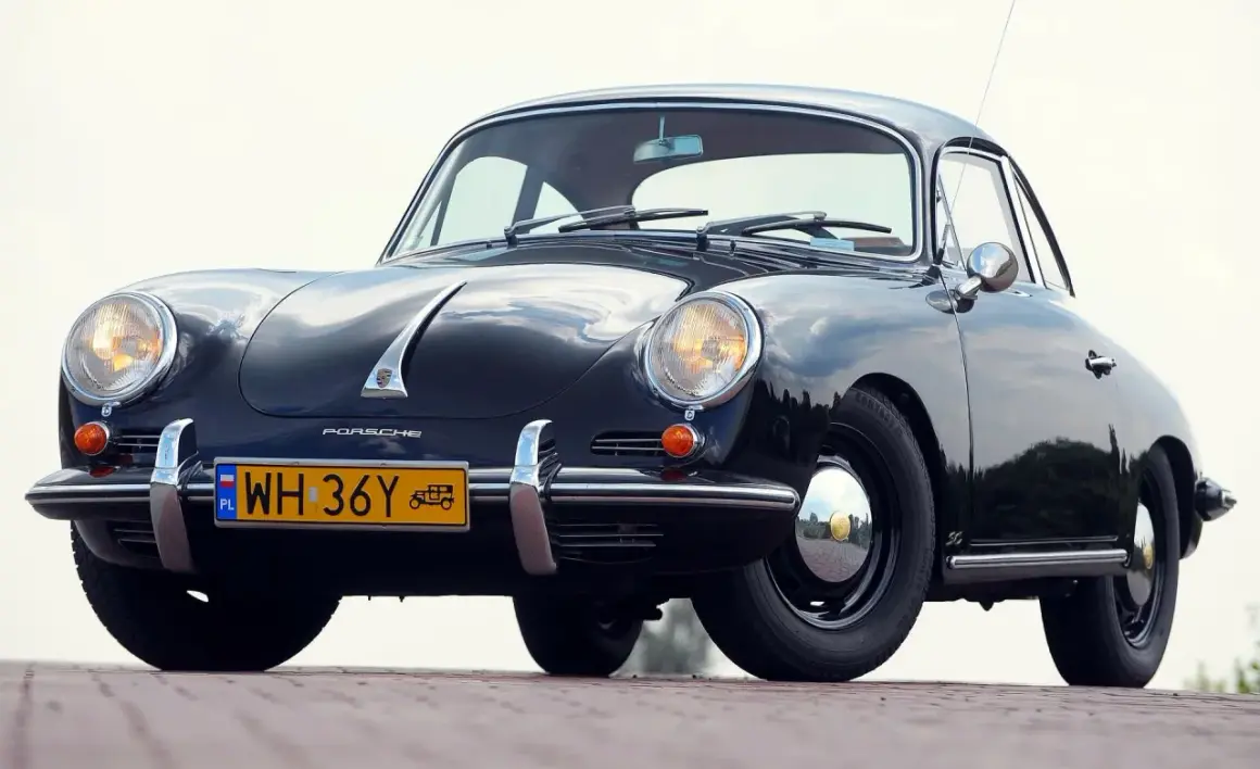 Czarne, zabytkowe auto Porsche z lat 50. XX wieku, z charakterystycznym przodem i żółtą tablicą rejestracyjną.