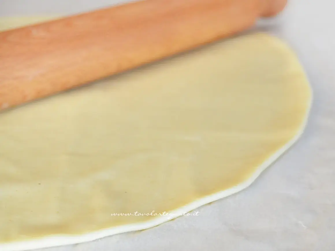 Stesura della pasta brise con un mattarello. L'olio rende l'impasto elastico e facile da lavorare per creare torte salate o dolci.