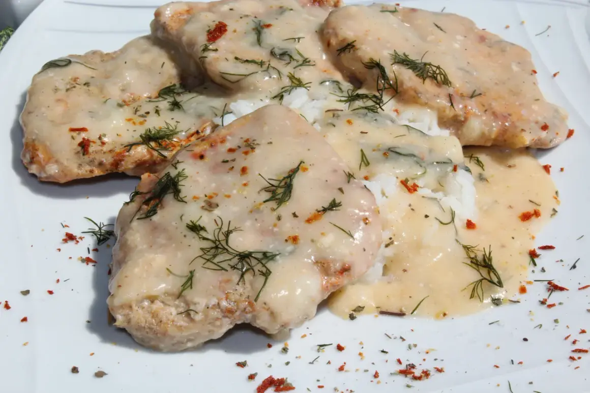 Schab w mleku, podany z ryżem i posypany koperkiem i papryką, wygląda apetycznie.