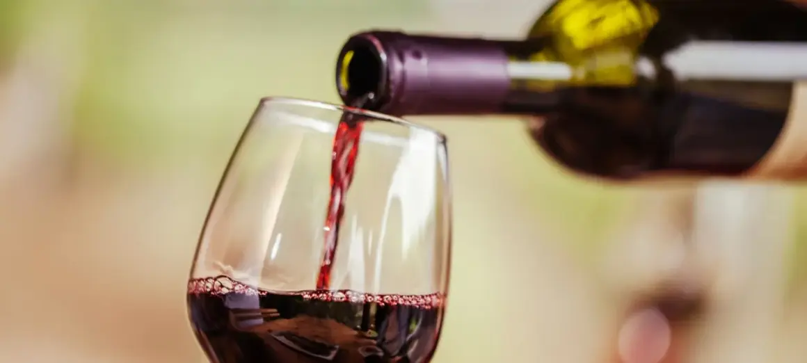 Rotwein wird in ein Glas gegossen. Für Menschen mit Histaminintoleranz ist eine **Histamin Wein Tabelle** hilfreich, um verträgliche Sorten zu finden.