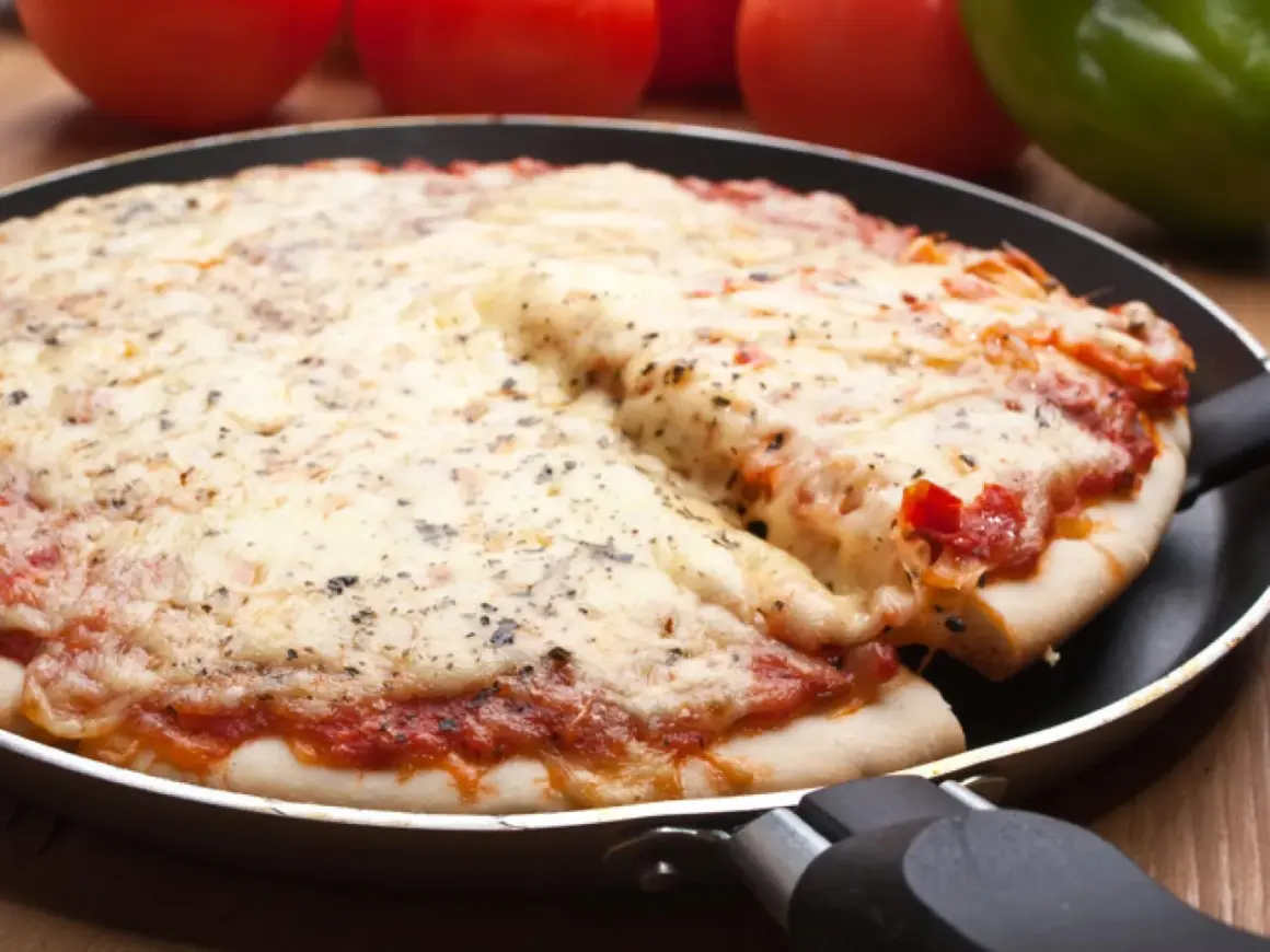 Deliciosa pizza en sartén, con queso derretido y salsa de tomate. Perfecta para compartir.
