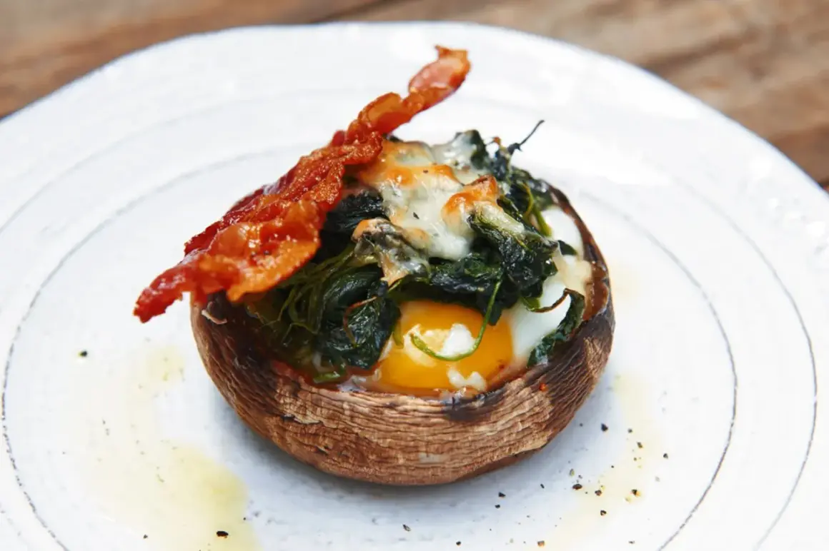 Gefüllter Portobello Pilz mit Ei, Spinat und Käse, garniert mit knusprigem Speck. Ein einfaches und leckeres Portobello Pilz Rezept.