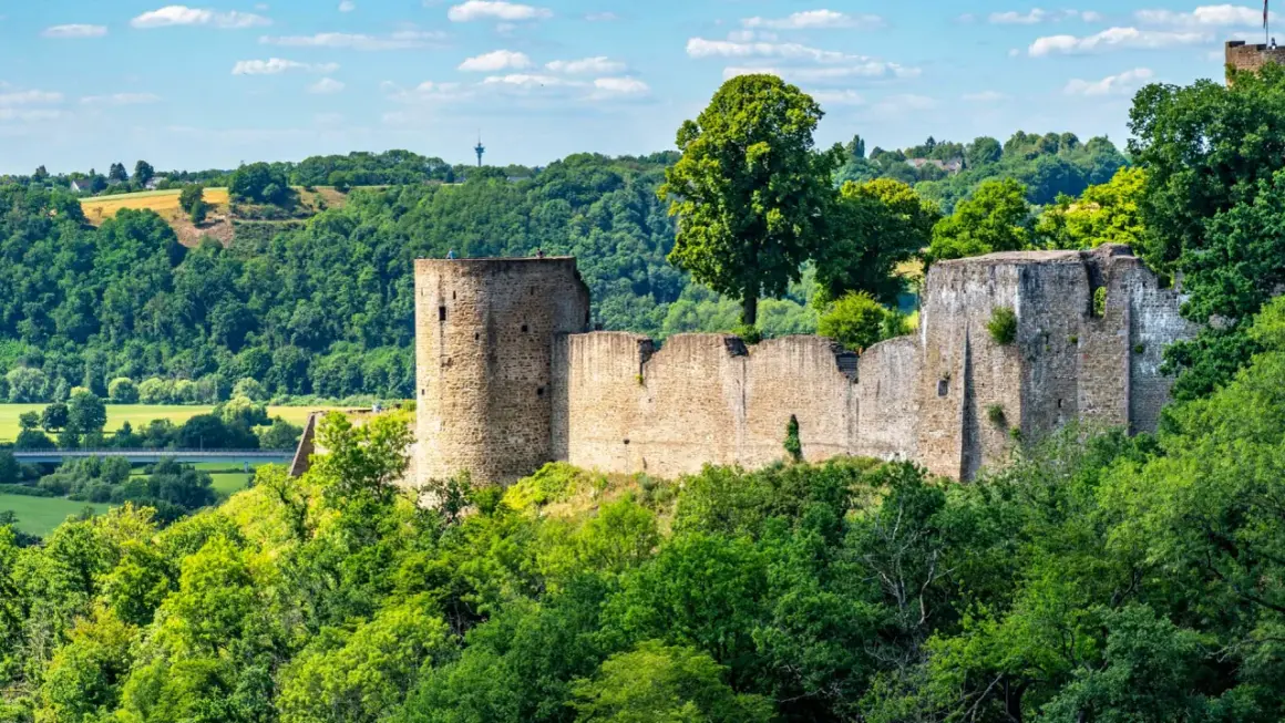 Ruinen der Burg Blankenberg thronen auf einem Hügel, umgeben von üppigem Grün. Ein historisches Zeugnis der Stadt Blankenberg.