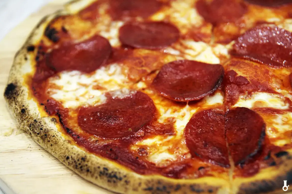 Pyszne, gorące ciasto na pizzę z serem i pikantnym pepperoni, idealne na wieczór filmowy.