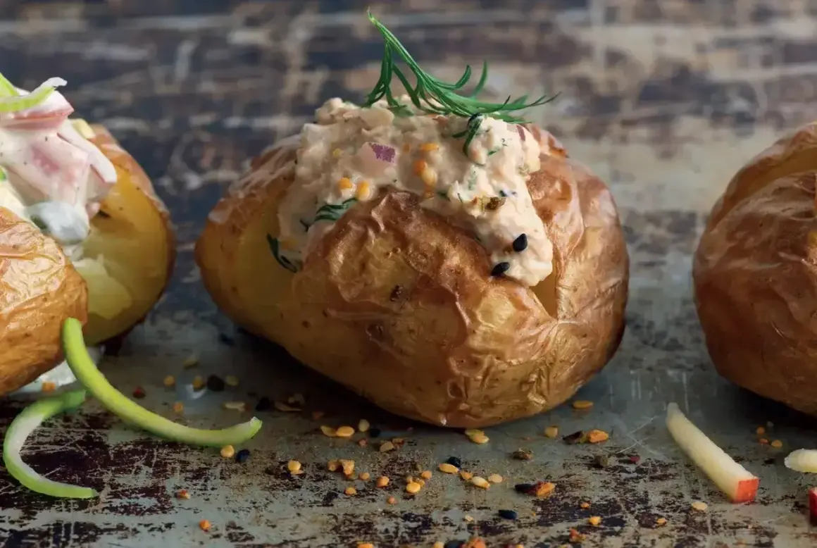 En gyllene bakad potatis med en krämig fyllning av tonfisk och örter, toppad med dill. En läcker och mättande rätt.