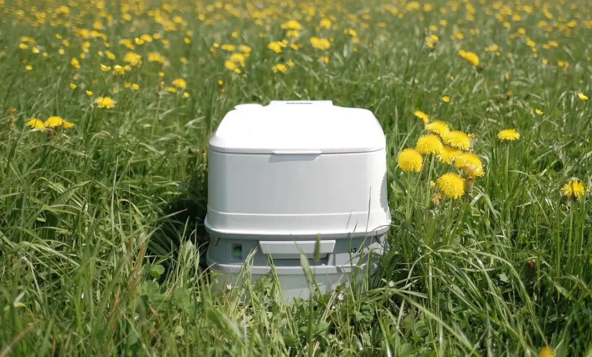 Un inodoro portátil blanco en un campo de flores amarillas. Así es como funciona un poti, una solución práctica para la naturaleza.