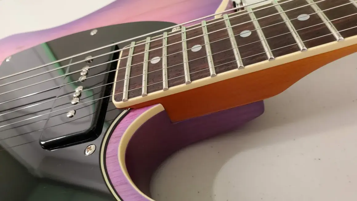 Dettaglio della chitarra Schecter PT Special con finitura sfumata viola e rosa, tastiera in palissandro e pickup nero.