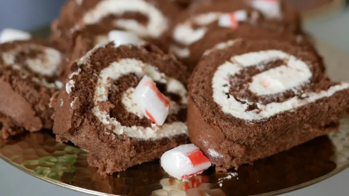 Chokladrulltårta med fluffig grädde och bitar av godis. En härlig dessert som passar perfekt till fikat.