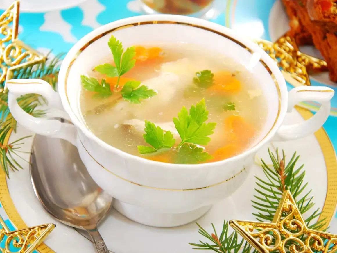 Aromatyczna zupa rybna przepis prosty, podana w eleganckiej miseczce, ozdobiona gałązkami choinki i złotymi gwiazdkami.
