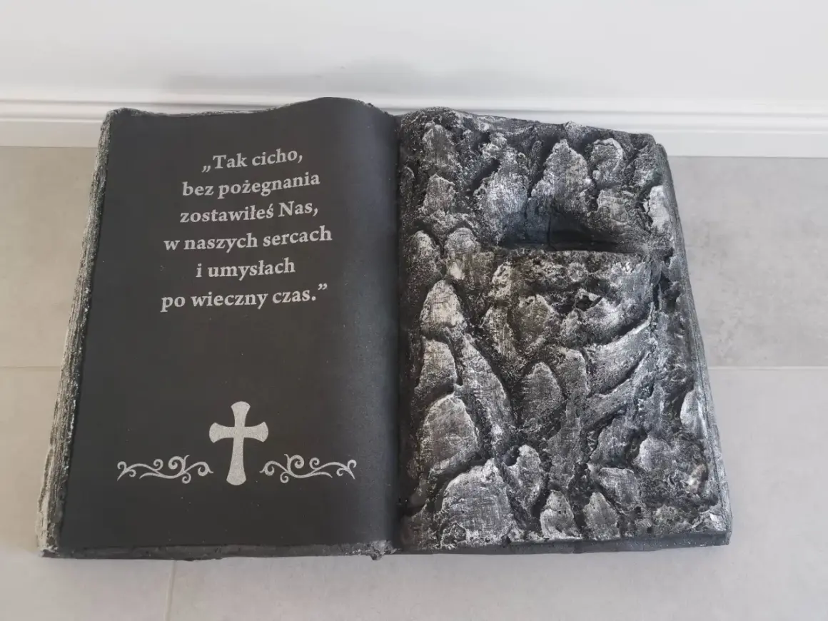 Stroik książka na cmentarz z cytatem i krzyżem. Prawa strona imituje kamieniste zbocze.