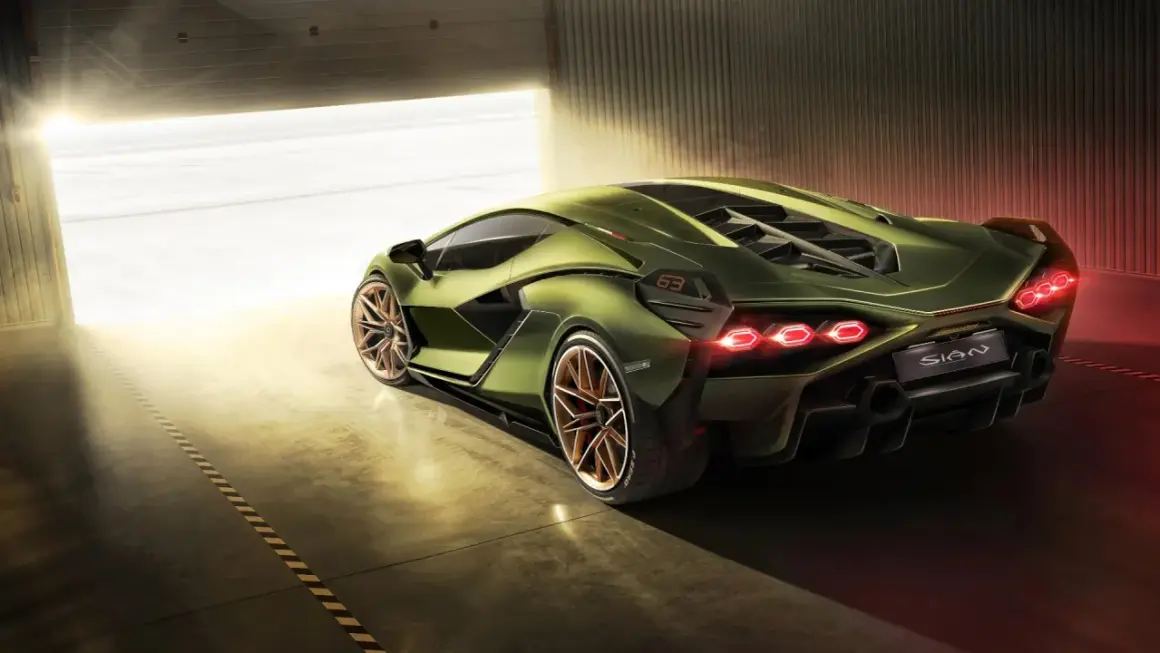 Zielony Lamborghini Sian z miedzianymi felgami, wychodzący z garażu w blasku słońca.