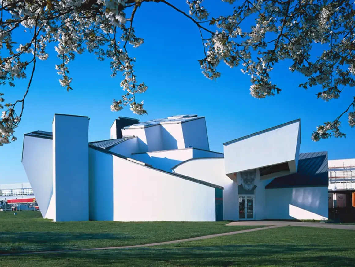 Das Vitra Museum Weil am Rhein, ein architektonisches Meisterwerk, erstrahlt im Frühlingslicht unter blühenden Kirschbäumen.