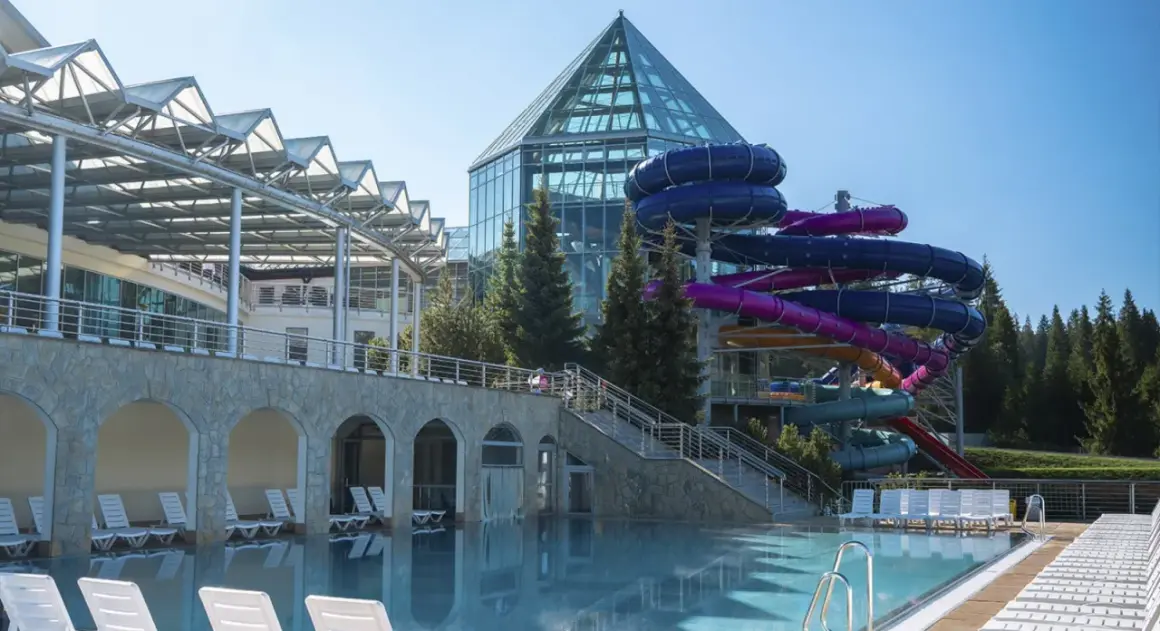 Basen i zjeżdżalnie wodne w Bukowinie Tatrzańskiej. Nowoczesny aquapark z przeszklonym dachem i kolorowymi rurami zjeżdżalni.