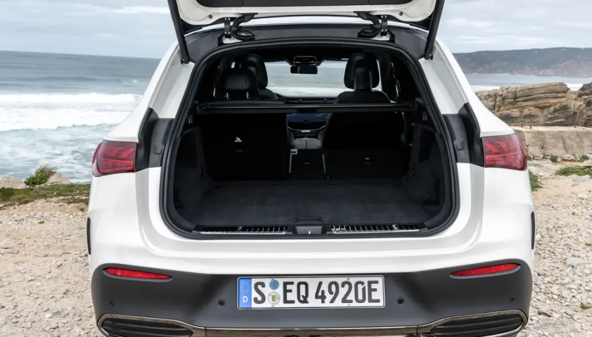 Maletero abierto de un Mercedes EQA blanco, listo para cargar equipaje en un viaje a la costa.