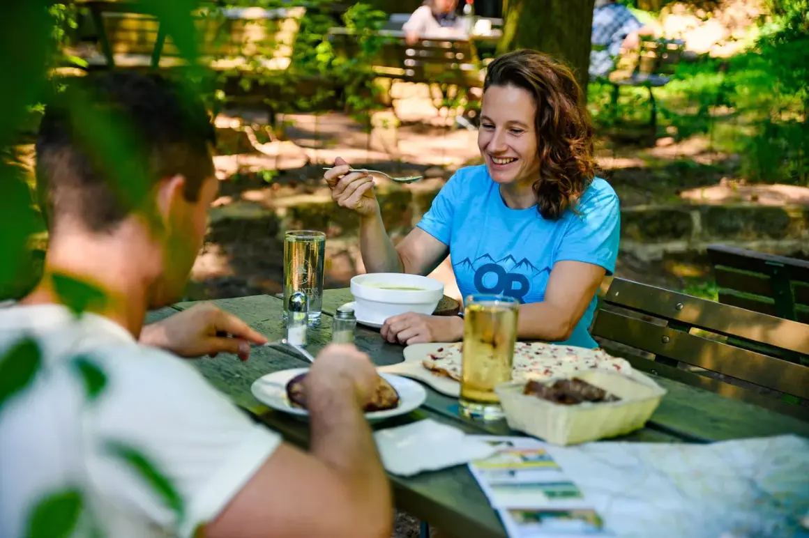 Ein glückliches Paar genießt eine Mahlzeit im Freien. Ein echter Geheimtipp Restaurant in Essen, versteckt im Grünen.
