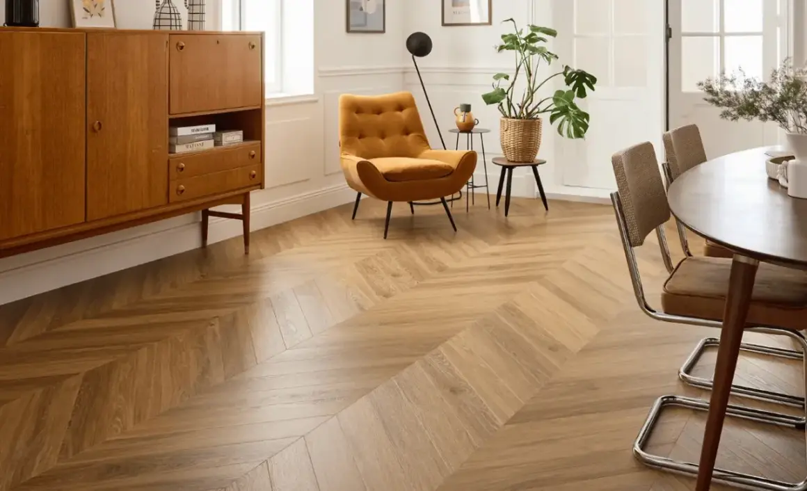 Un salon moderne avec un **pose parquet point de hongrie** en bois clair, un fauteuil moutarde et un buffet vintage.