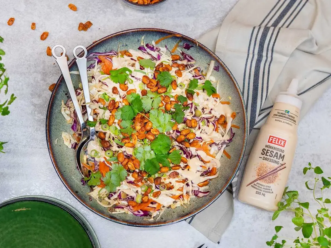 En fräsch asiatisk sallad med krispig vitkål, rödkål och morötter, toppad med rostade nötter och koriander. Serveras med Felix mörkrostade sesamdressing.
