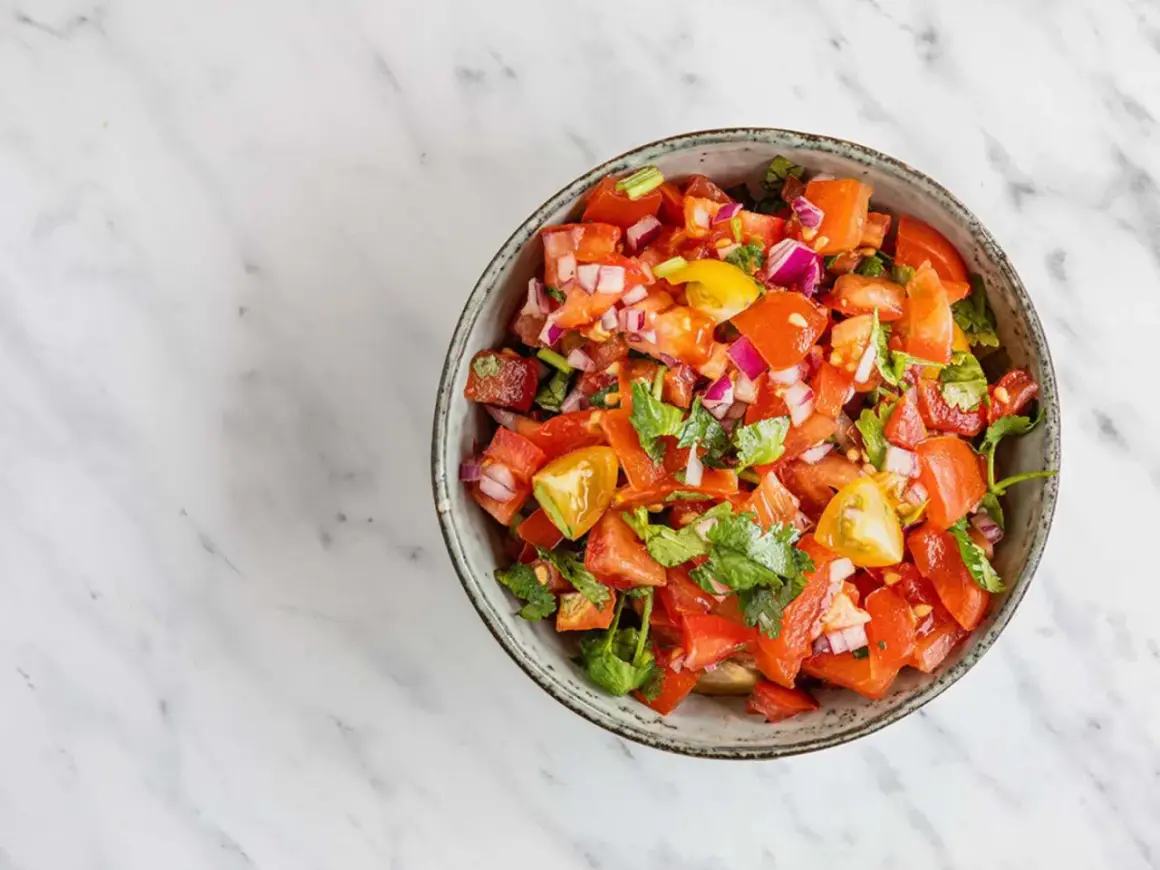 En skål med färsk pico de gallo, full av tärnad tomat, rödlök och koriander. Perfekt till tacosen!