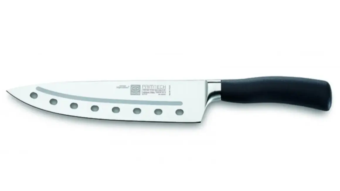 Cuchillo de chef con agujeros en la hoja para reducir la fricción al cortar. Mango ergonómico negro.