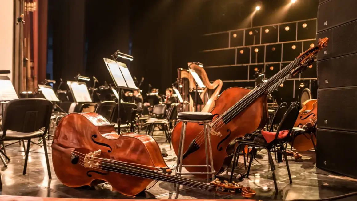 Kontrabasy i harfa na scenie, gotowe do wykonania muzyki z filmów.