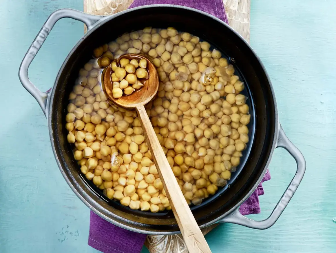 Kichererbsen in einem Topf mit Wasser, bereit zum Kochen. Die Frage "kichererbsen wie lange kochen" wird hier visuell angedeutet.