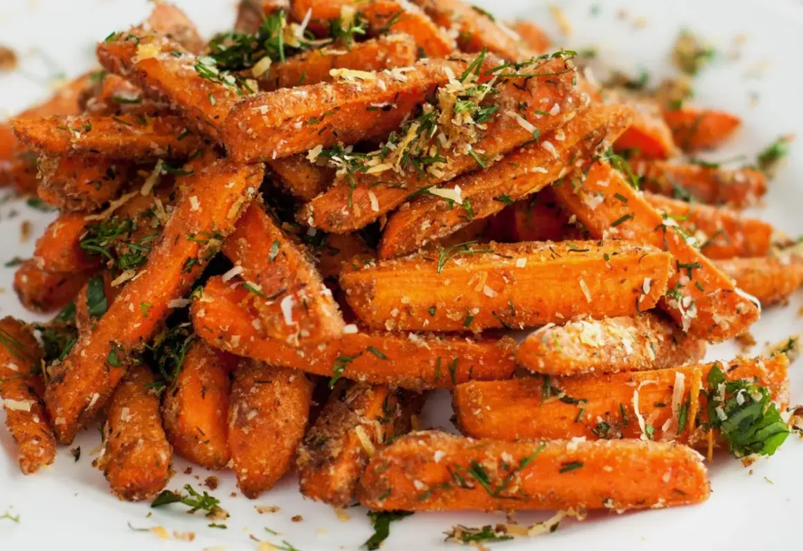 Chrupiące frytki z marchewki, posypane ziołami i parmezanem, wyglądają apetycznie.