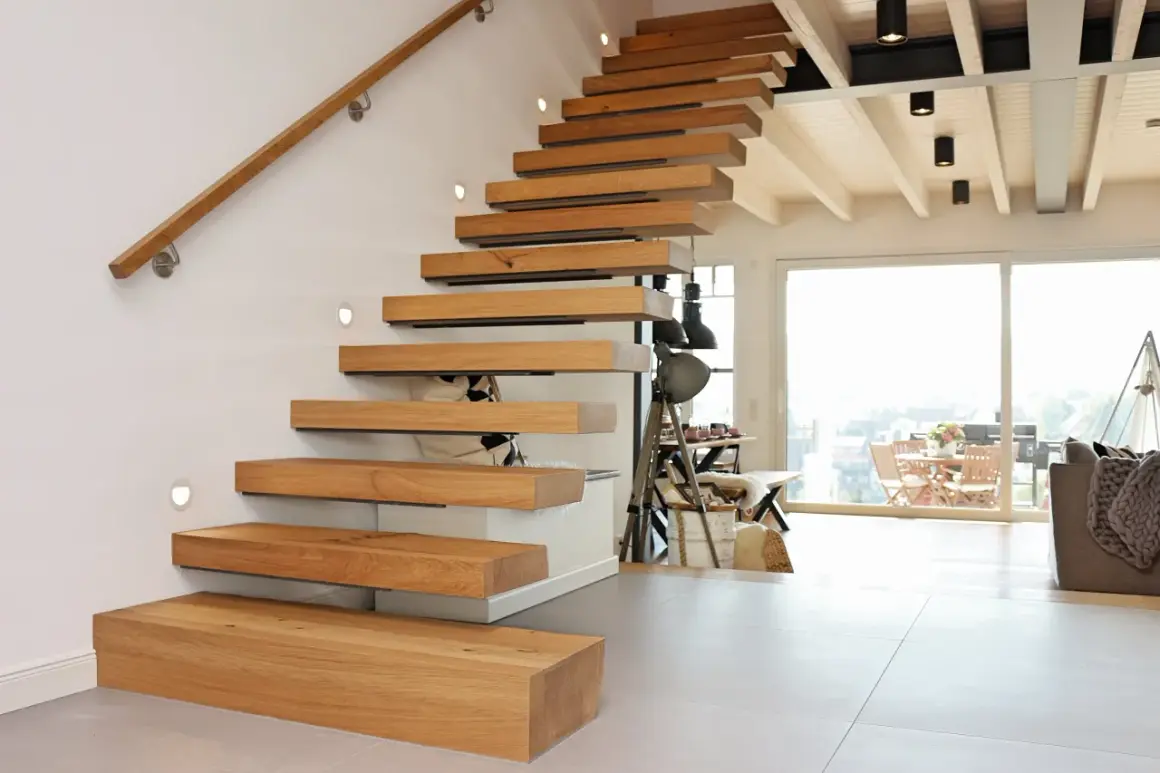 Ein modernes Treppenhaus gestalten: Schwebende Holzstufen mit integrierten Leuchten und einem schlichten Holzhandlauf.