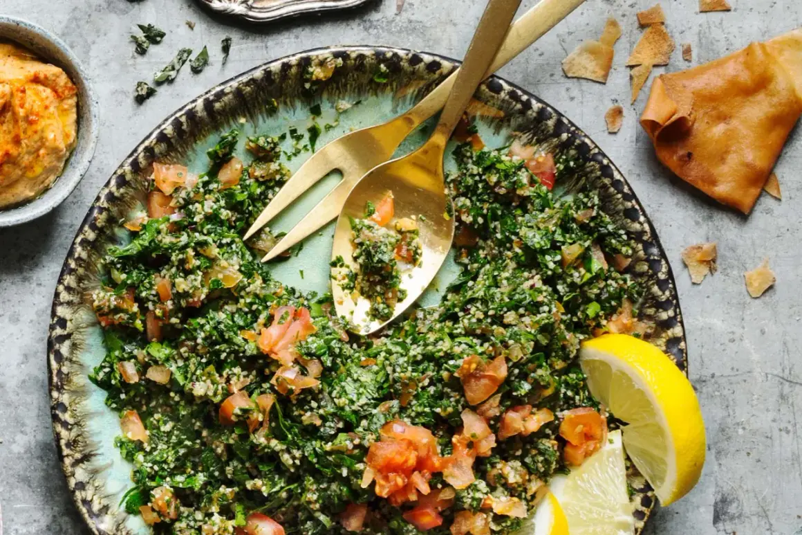 En fräsch tabbouleh med persilja, tomat och bulgur, serverad med citronklyftor och pitabröd. Ett perfekt tabbouleh recept för sommaren.