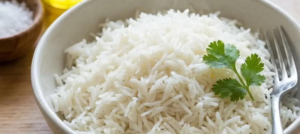 Schüssel mit dampfendem Reis, garniert mit Koriander. Perfekt, um Reis vor dem Kochen anzubraten für extra Aroma.