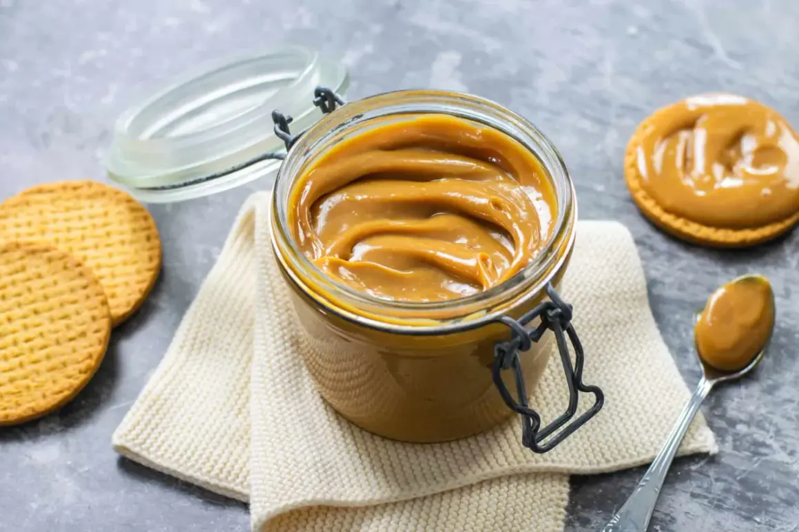 Un vasetto pieno di cremoso dulce de leche, pronto per essere spalmato su biscotti croccanti.