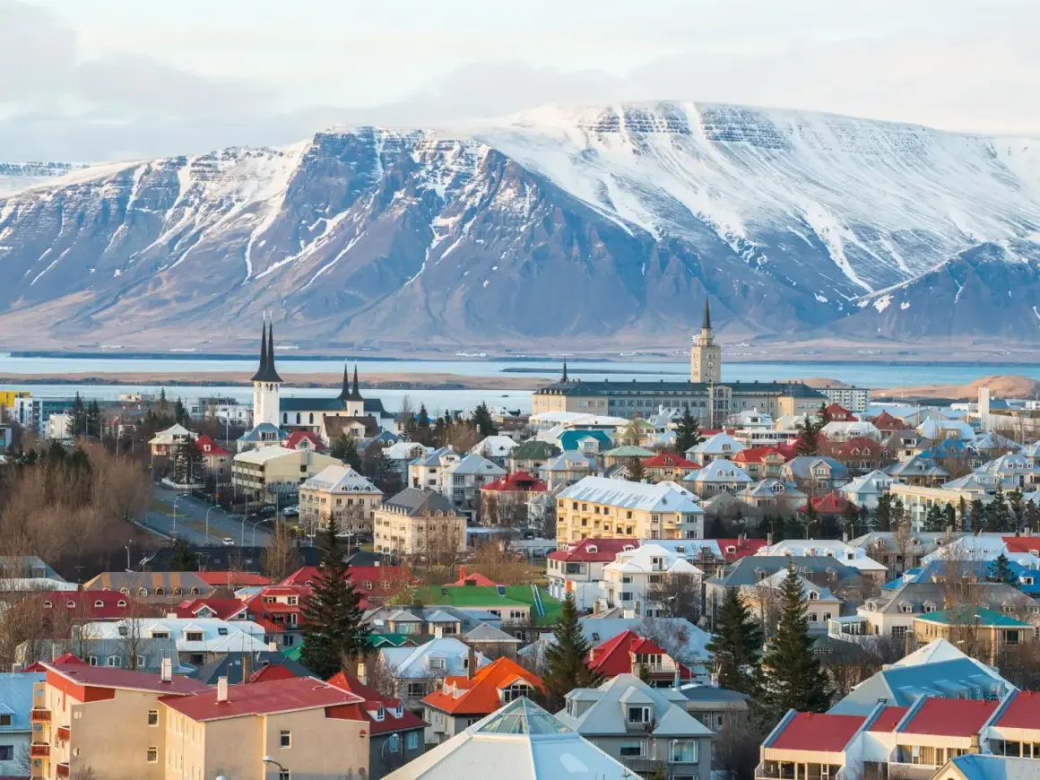 Reykjavik, stolica najbezpieczniejszego kraju w Europie, z kolorowymi dachami i ośnieżonymi górami w tle.