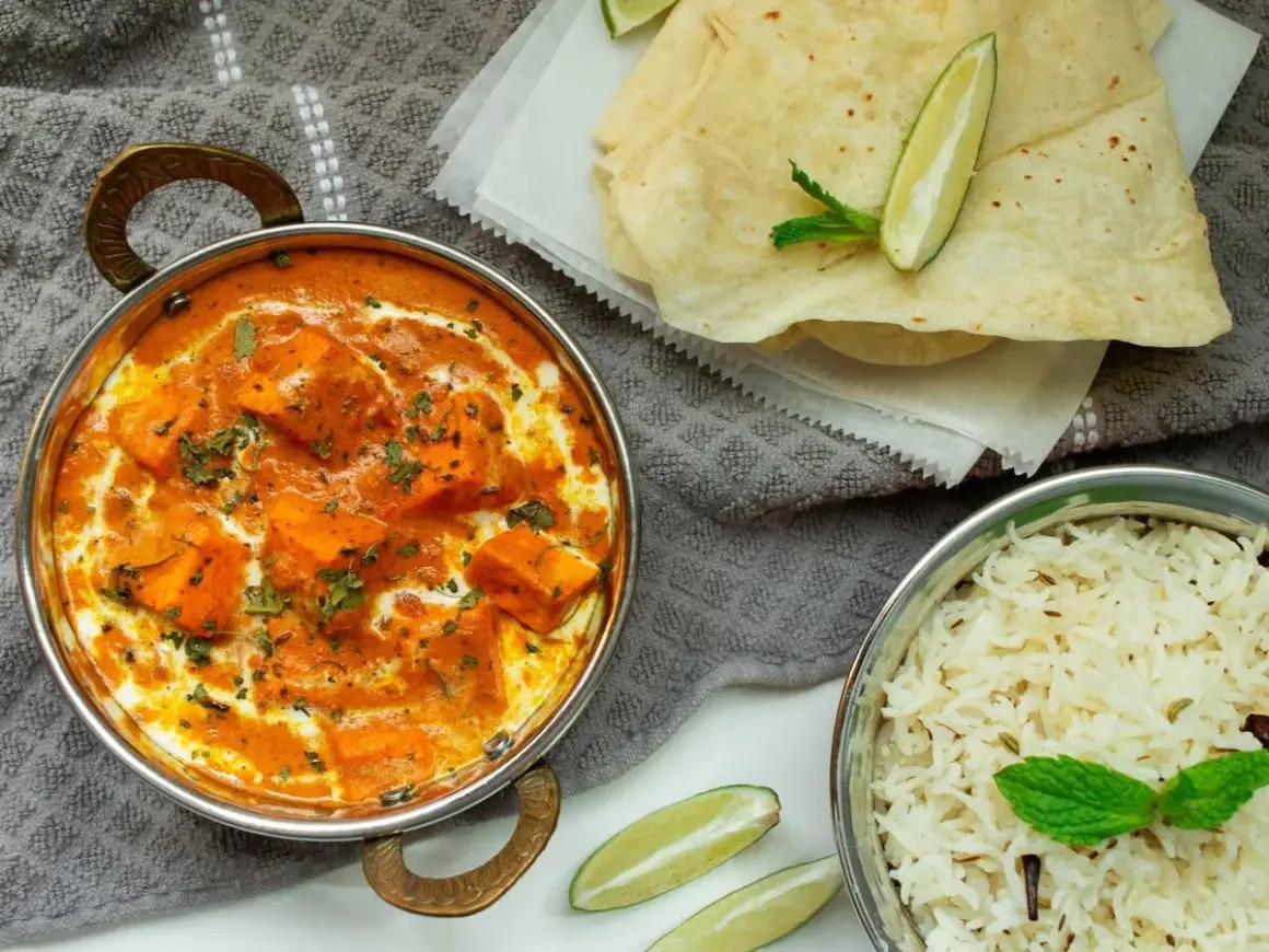 Un cremoso plato de paneer tikka masala, que es el curry, acompañado de arroz basmati y pan naan.