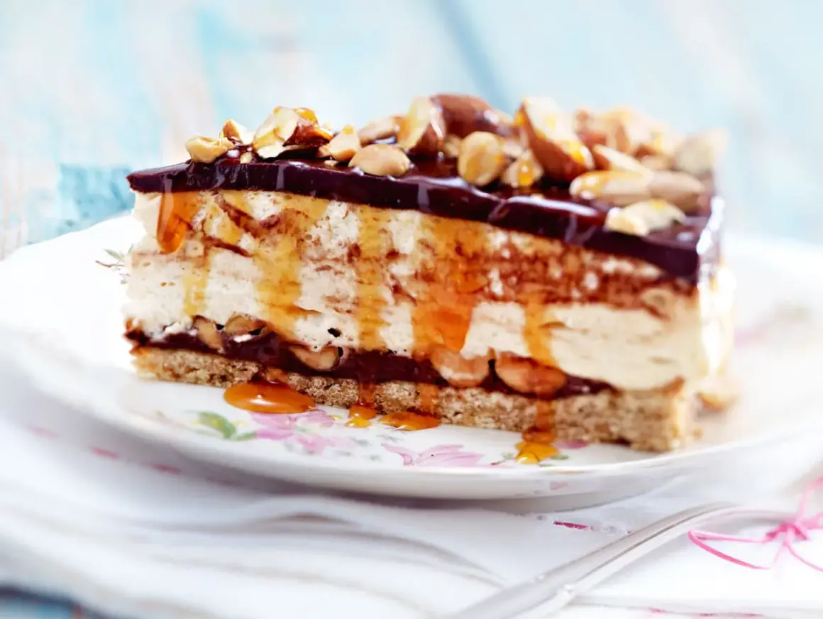 Ein Stück cremiger Käsekuchen mit Schokoladenglasur, Karamell und Nüssen als köstliches cheesecake topping.
