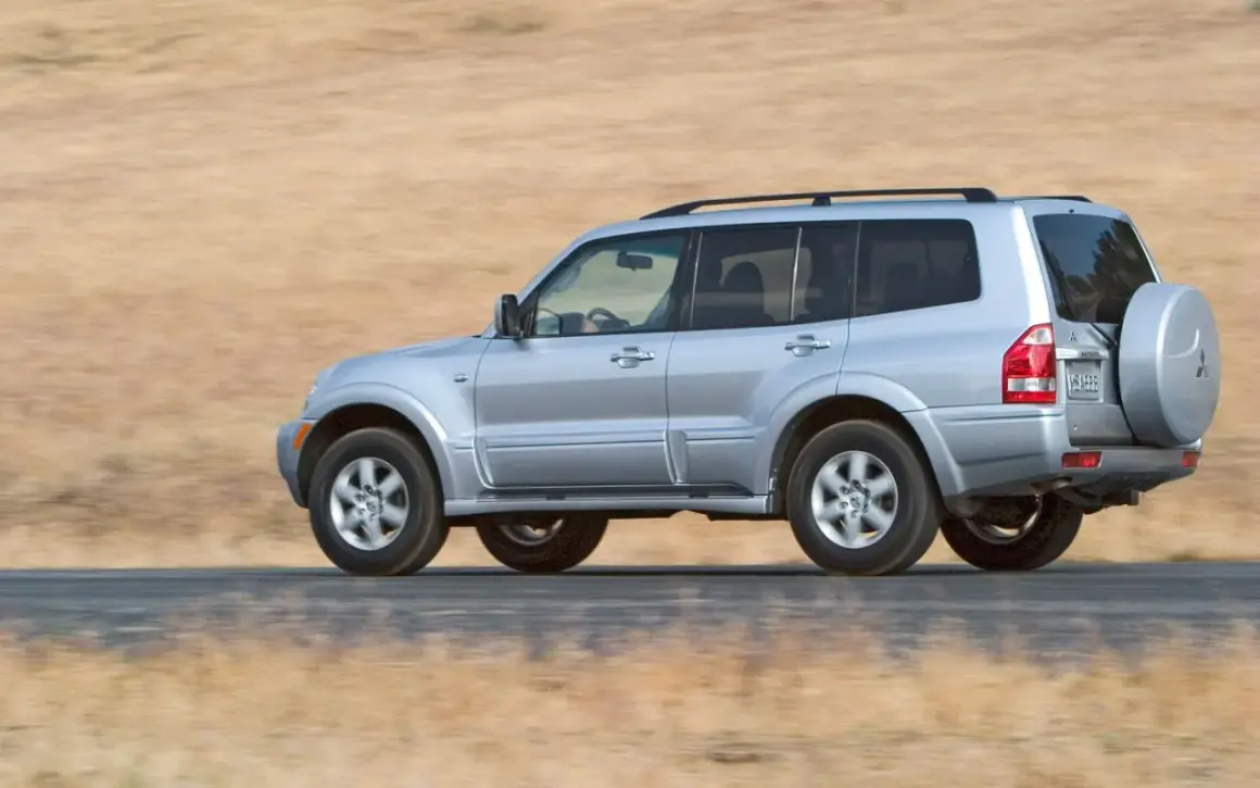 Mitsubishi Montero 3.2 DID off road, plate VM 5666, driving on a dusty road with dry grass background.