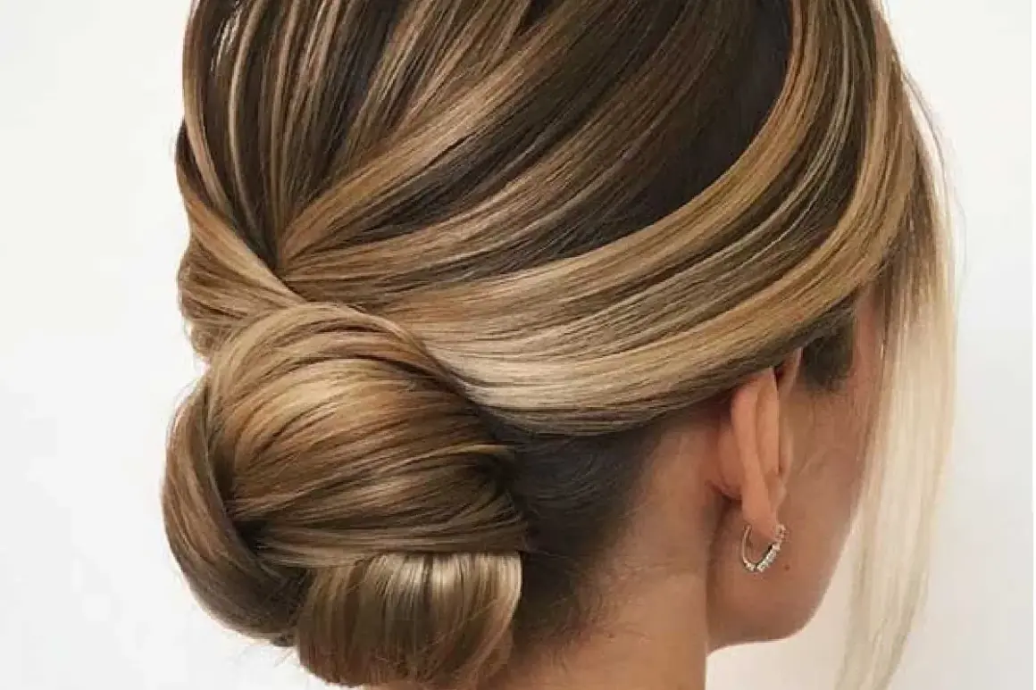 Acconciature capelli medi per cerimonia: un elegante semiraccolto con morbide onde e un chignon basso, perfetto per un look sofisticato.