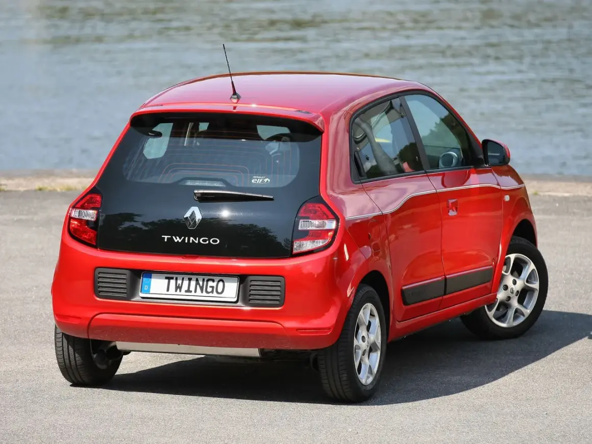 Czerwone renault twingo 3 z czarną klapą bagażnika stoi nad jeziorem.