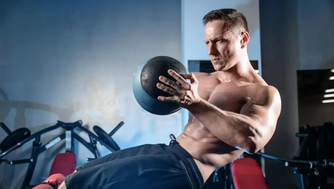 Homme musclé effectuant un exercice oblique avec un medecine ball, concentré sur son entraînement.
