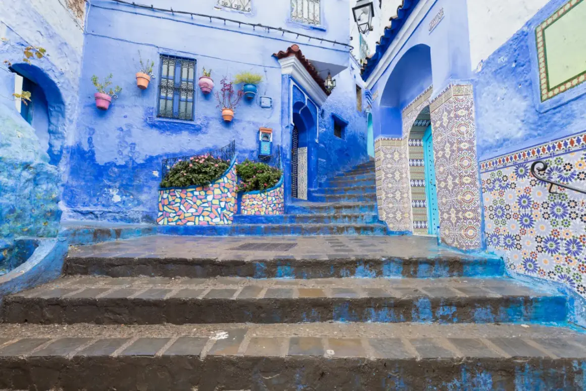 Niebieskie miasto w Maroku, Chefchaouen, zachwyca kolorowymi mozaikami i kwitnącymi roślinami.