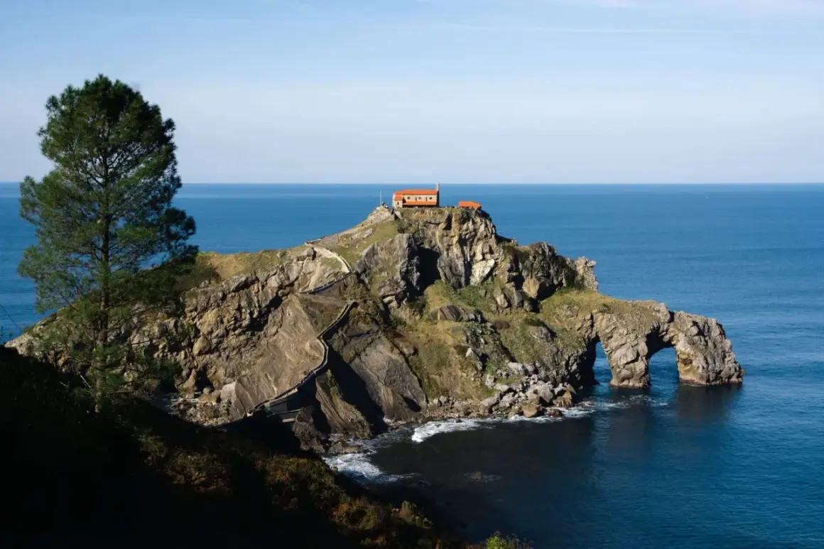 Escaleras serpenteantes hacia la ermita en San Juan de Gaztelugatxe. Descubre cómo llegar a este icónico lugar.