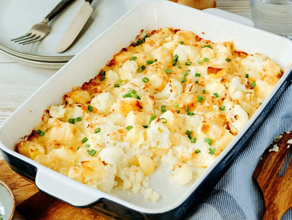 Ein goldbrauner Blumenkohlauflauf mit Käse überbacken und mit Schnittlauch bestreut, bereit zum Servieren.