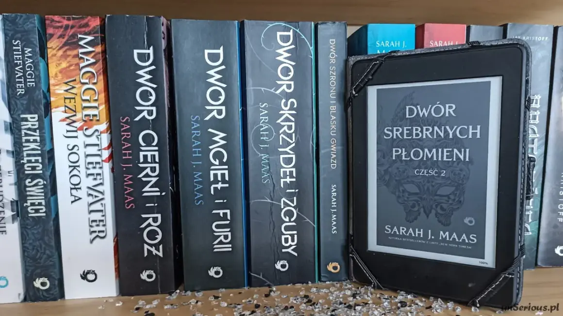 Na półce stoją książki z serii **Dwór Cierni i Róż** autorstwa Sarah J. Maas, obok e-czytnik z okładką "Dwór Srebrnych Płomieni".