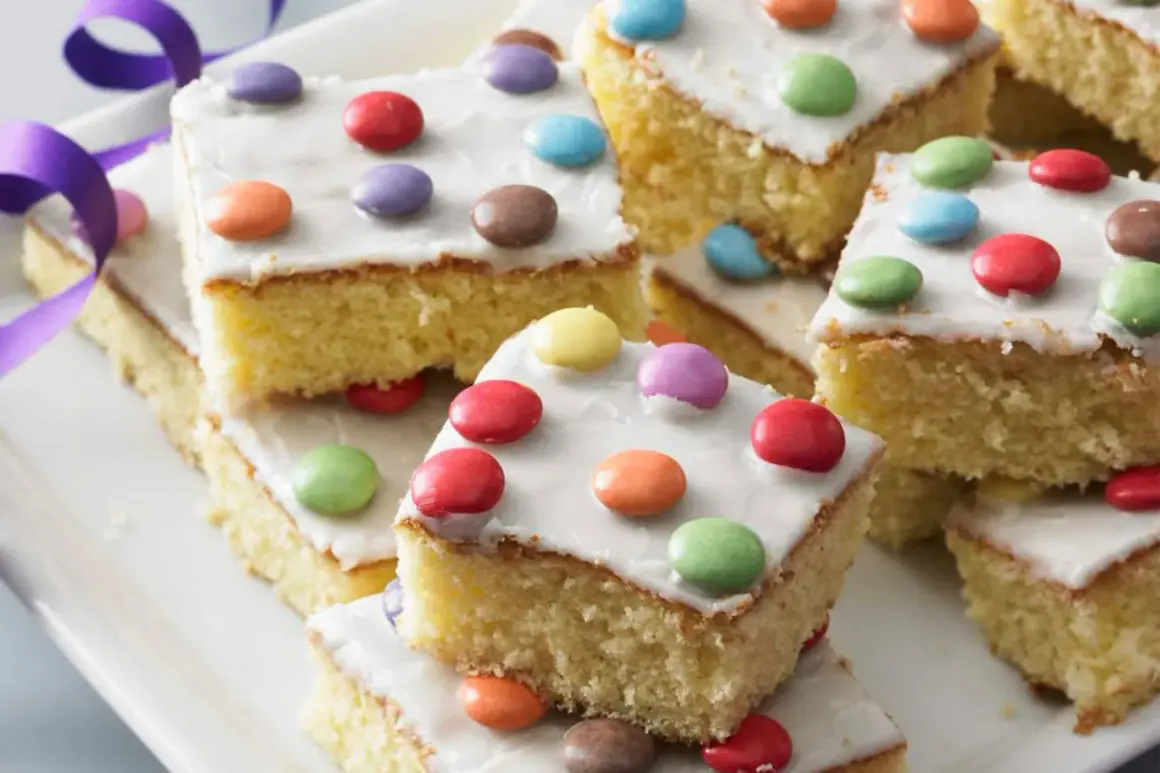 Bunte Smarties-Kuchenstücke auf einem Teller, ein leckeres fantakuchen rezept für Kindergeburtstage.