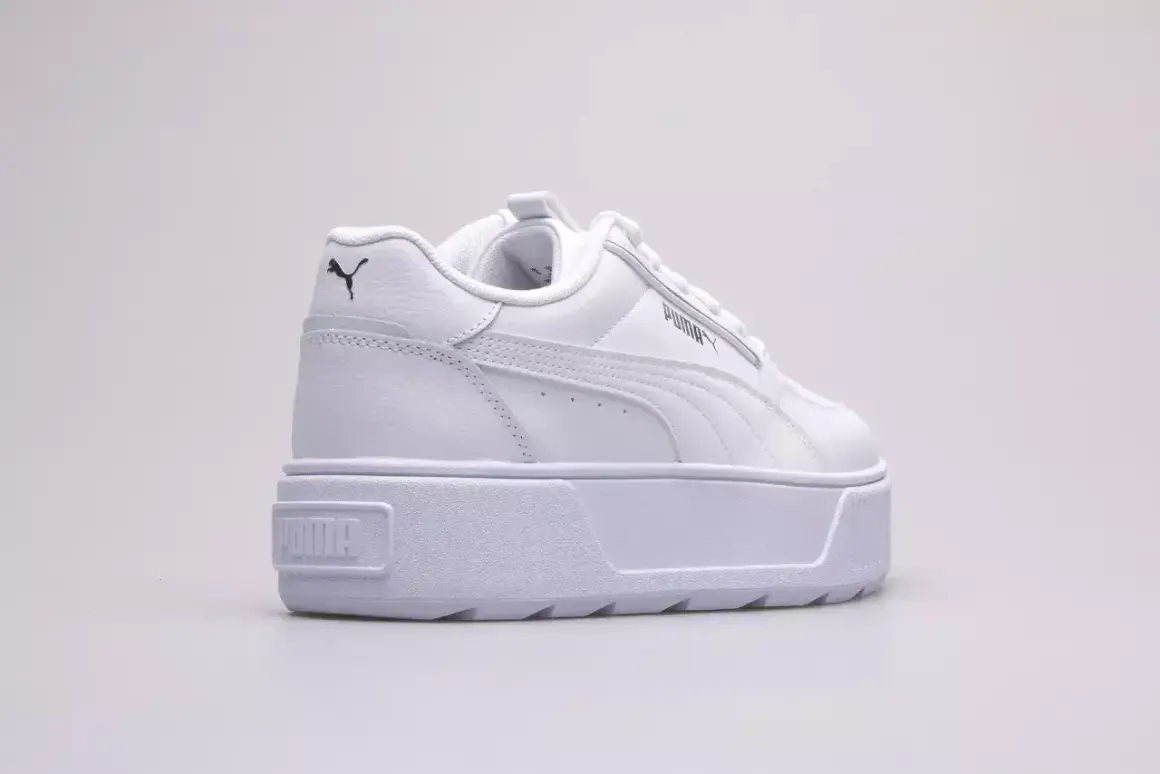 Białe buty na platformie Puma Karmen Rebelle Jr. z czarnym logo.